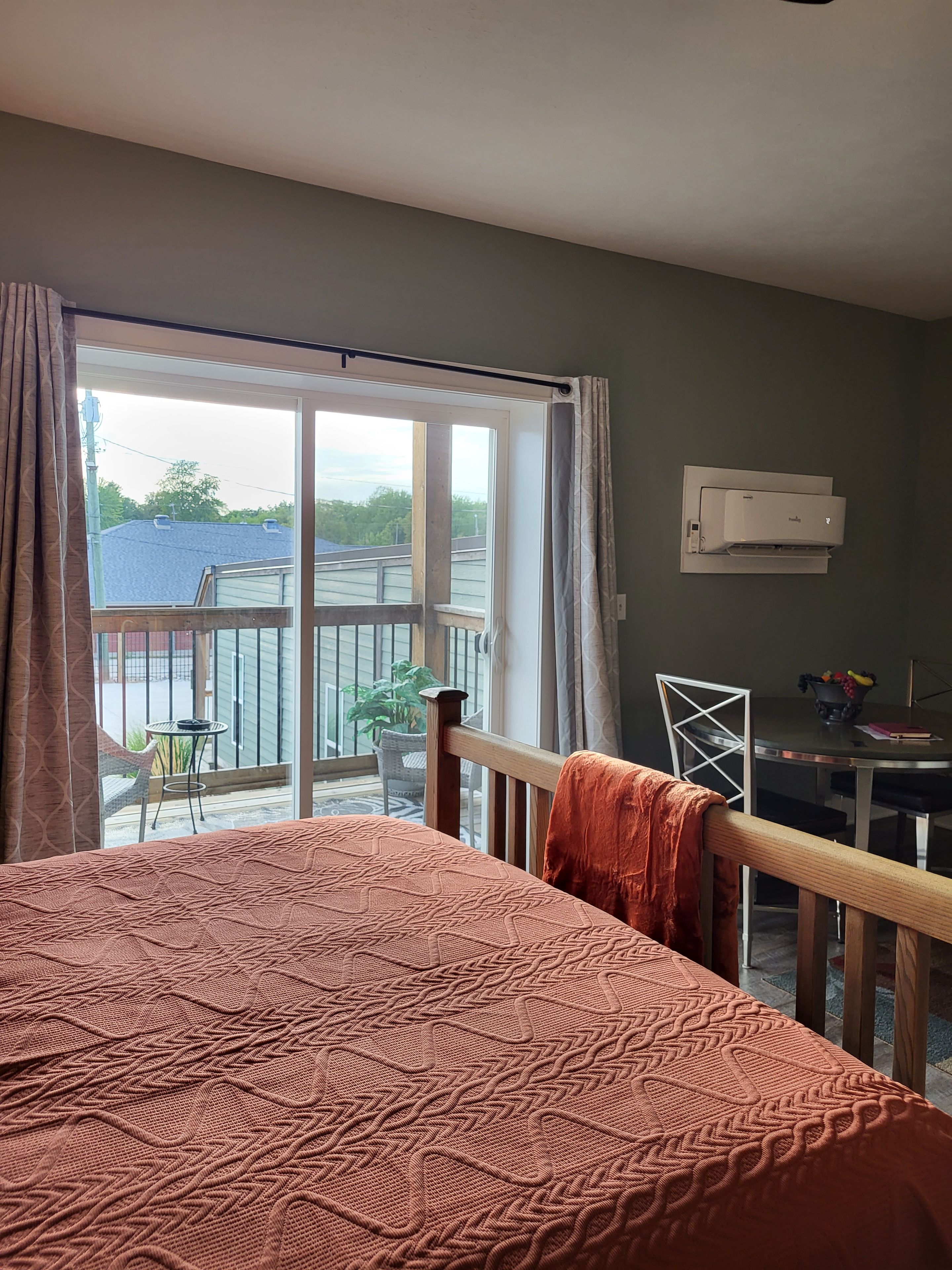 Une chambre à coucher avec un lit, une fenêtre et une vue sur un balcon.