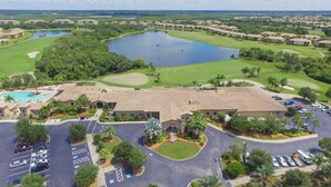 Vue aérienne d’un complexe hôtelier avec un terrain de golf, un grand bâtiment, plusieurs piscines et un parking.