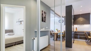 Eine moderne Wohnung mit einem Schlafzimmer, einem Essbereich und einer Küche.