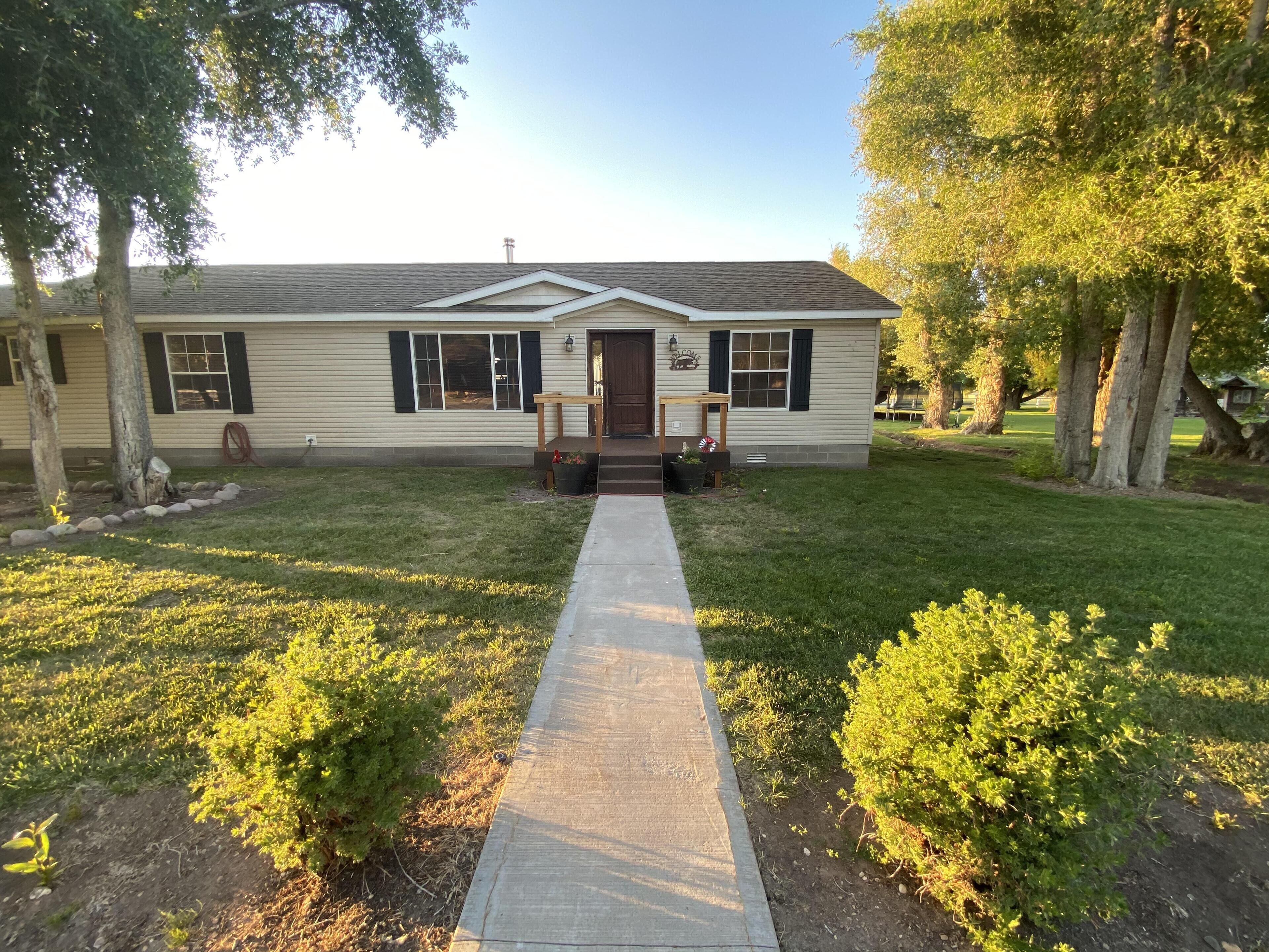 A single-story house with a front porch, a small garden, and a pathway leading to the entrance.