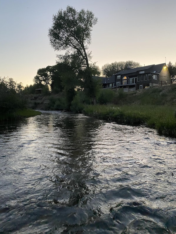 Un río con una casa en una colina.