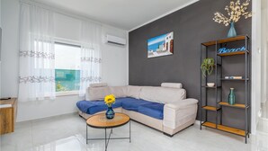 A modern living room with a sofa, a coffee table, and a bookshelf. - Beach front home in Peroj (Peroj)