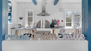 A kitchen with a large island, white cabinets, and blue accents. - Lovely home in Gudhjem with WiFi (Gudhjem)