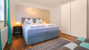 Un dormitorio con cama, mesita de noche y armario.