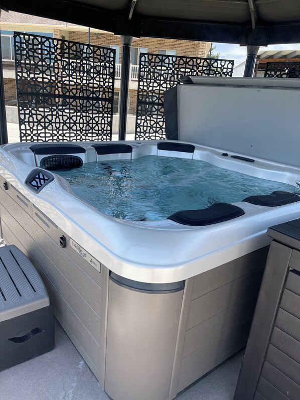 Un jacuzzi con estructura metálica, un panel de control y el nombre de la marca.