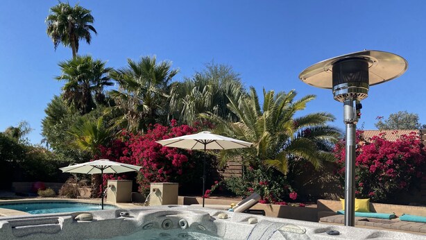 A hot tub area with a pool, surrounded by palm trees and pink flowers. - 2 Master Bedrooms, Luxury beds, Pool & Hot Tub, Large TVs, Surround Sound (Scottsdale)