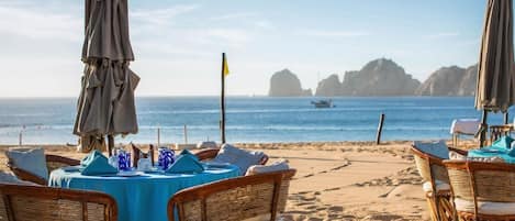Enjoy a seaside meal with ocean views and a flagpole in the distance.
