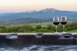 Two glasses of red wine on a stone ledge with a mountainous landscape in the background. - Hot Tub & Sauna Spa, Amazing Mountain Views, Remote Nature Getaway For Families (Glenwood Springs)