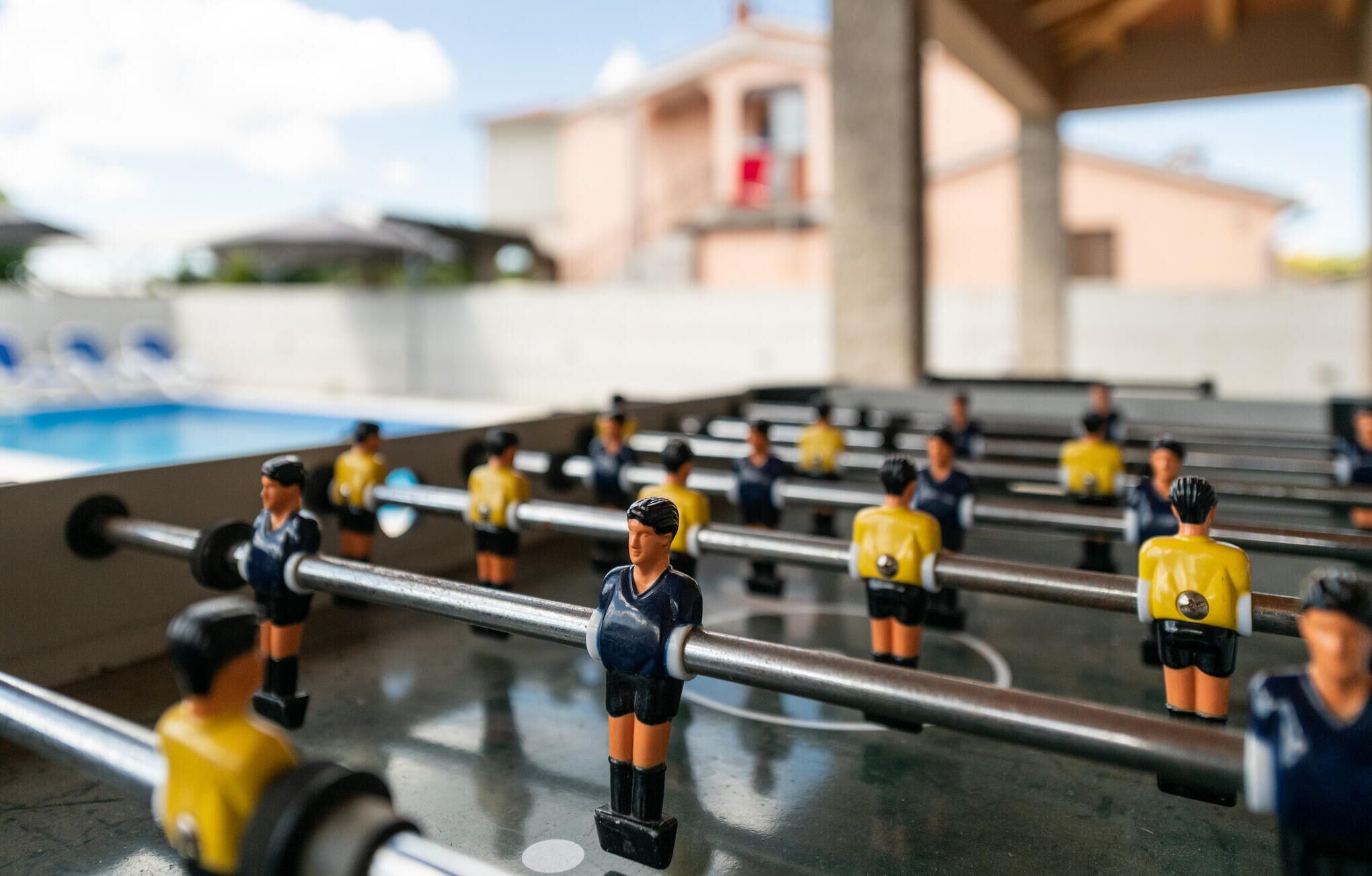 Une table de baby-foot avec de petites figurines portant des uniformes jaunes et bleus.