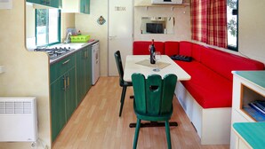 Una cocina compacta con comedor, un sofá rojo y una pequeña mesa.