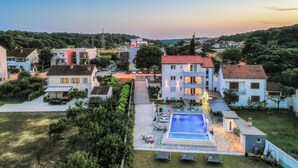 Zona residencial con una amplia piscina, rodeada de casas y vegetación.
