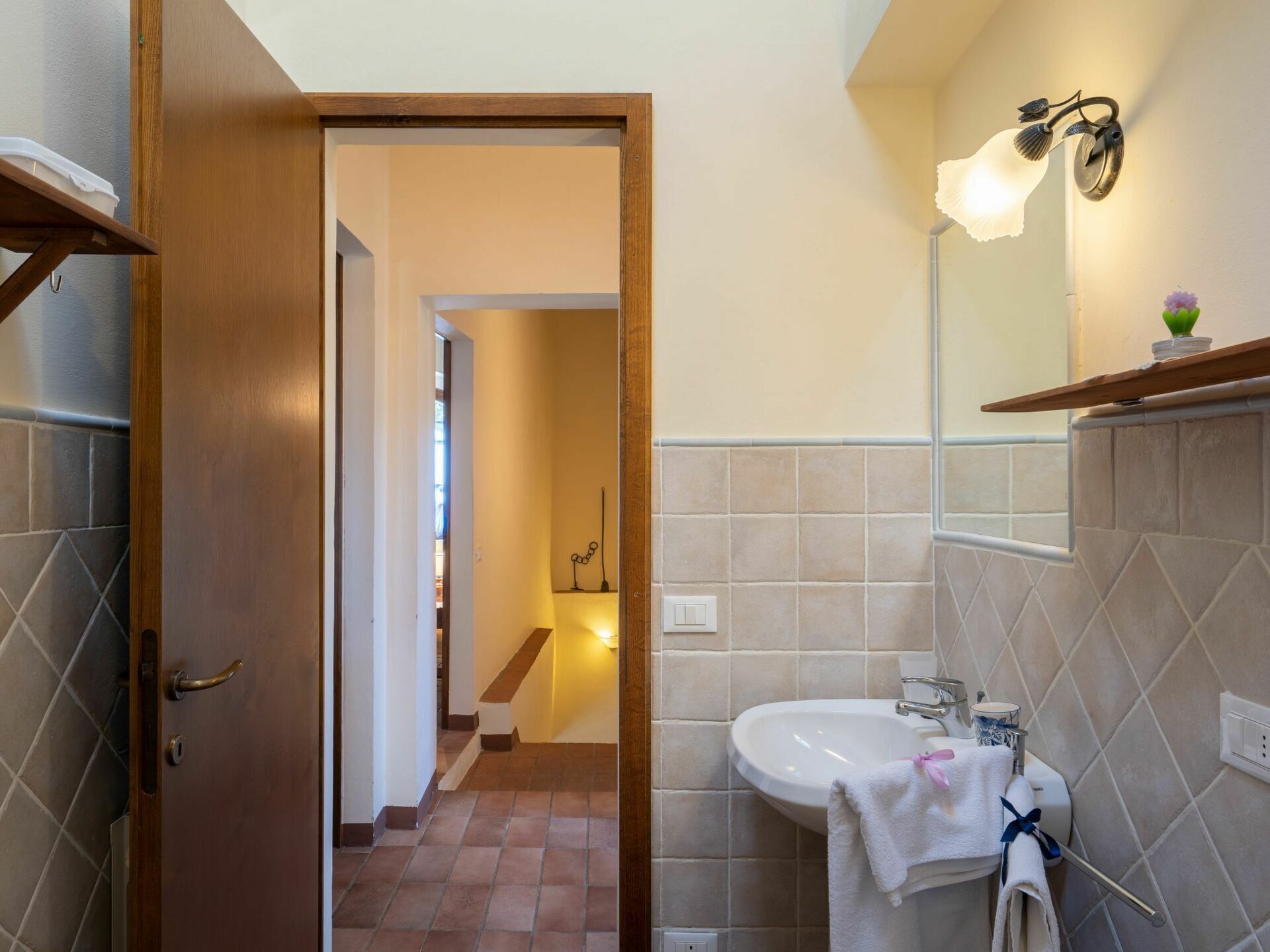 Une salle de bain équipée d’un lavabo, d’un miroir et d’un porte-serviettes.
