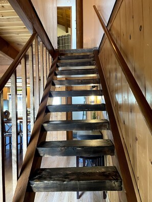 A wooden staircase with a handrail, leading to an upper floor. - Entire Cabin! Cozy 2 bedroom that sleeps 6. Just minutes from Snow Valley! (Running Springs)