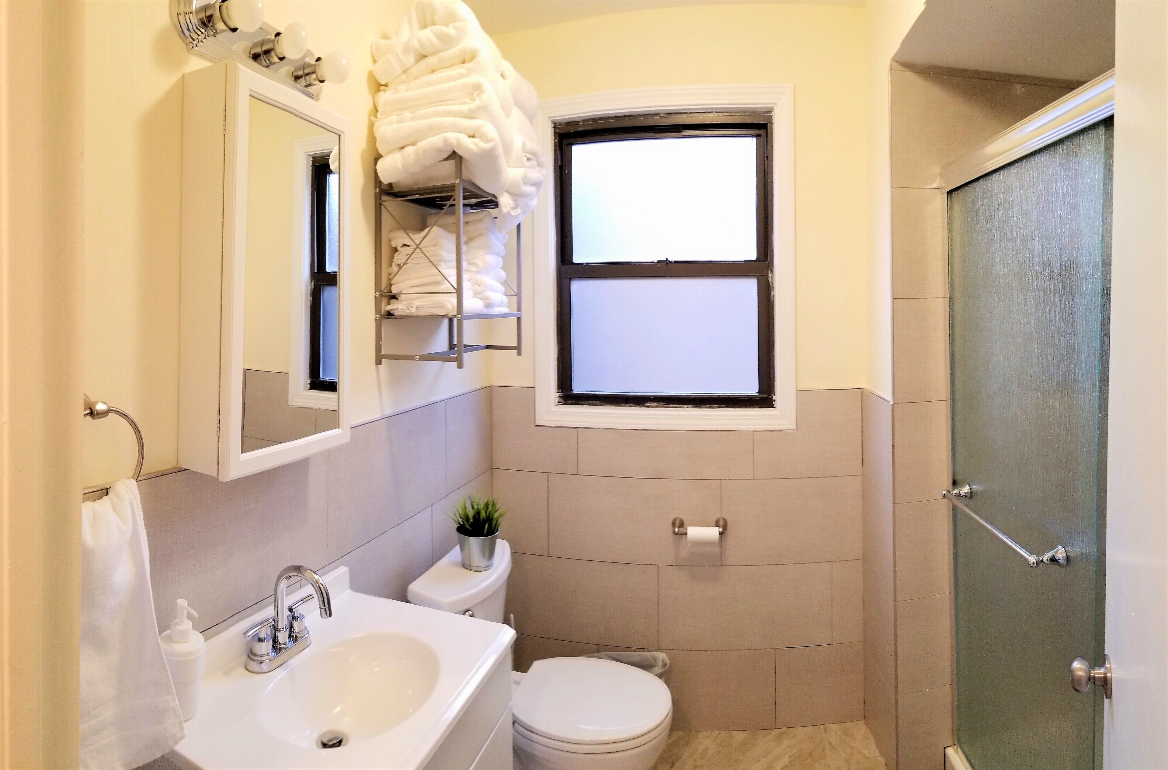 A compact bathroom with a sink, toilet, and a small window.