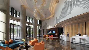 A spacious lobby with a reception desk, seating area, and large windows.