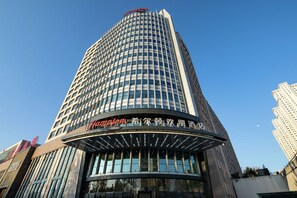Un alto edificio di hotel con una segnaletica ben visibile che indica "Hyatt" e "Hilton", a testimonianza dell'appartenenza alla catena alberghiera Hilton.