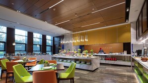 Um restaurante moderno com uma ilha central, cadeiras em tons vibrantes de verde e laranja, e bancada de mármore.