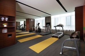 Una palestra alberghiera con tapis roulant, ellittiche e una panca per pesi.