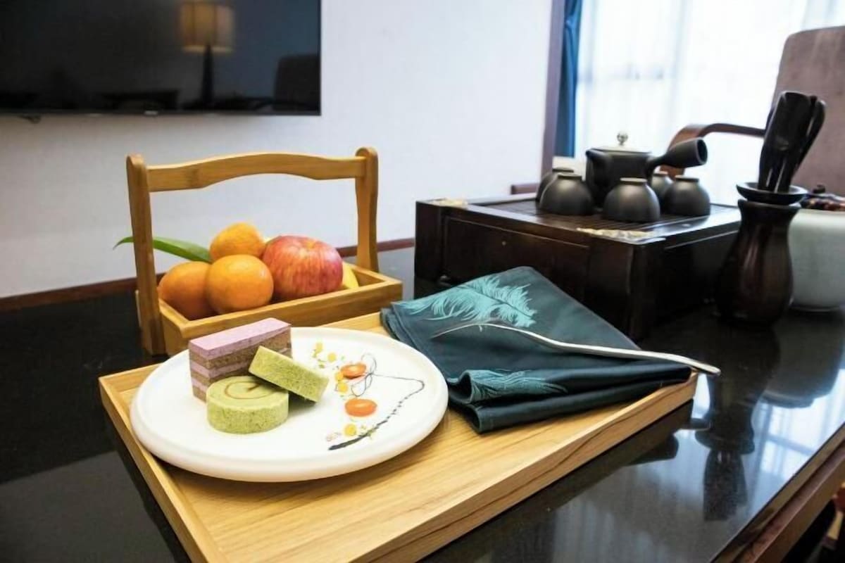Een houten stoel met een fruitmand, een bord met matcha en een theeset op een dienblad.