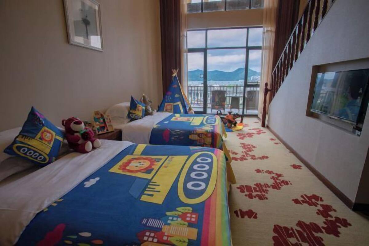 Habitación de hotel con dos camas, un balcón y vistas a las montañas.