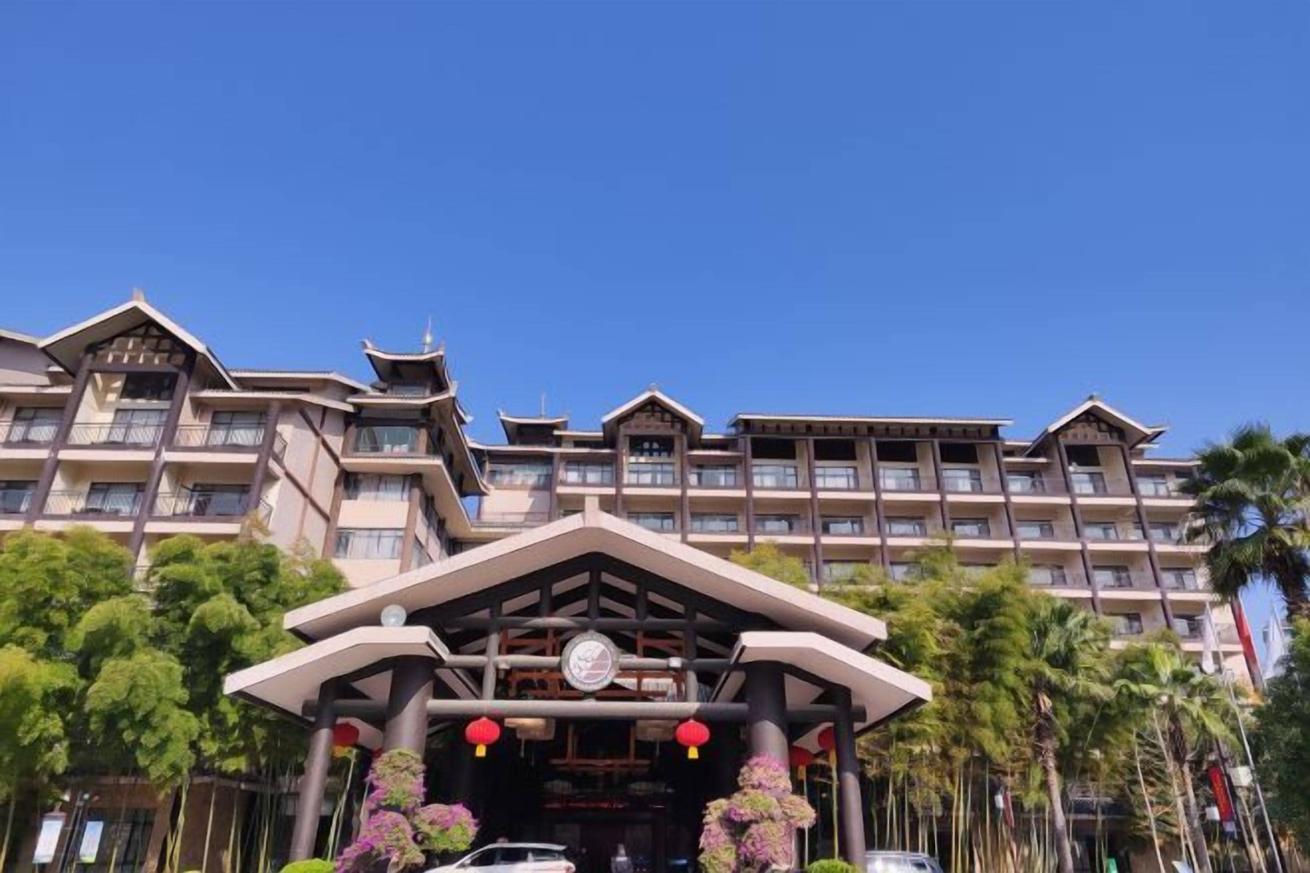 A multi-story hotel with a traditional architectural style, featuring a prominent entrance with a decorative arch and a clock.