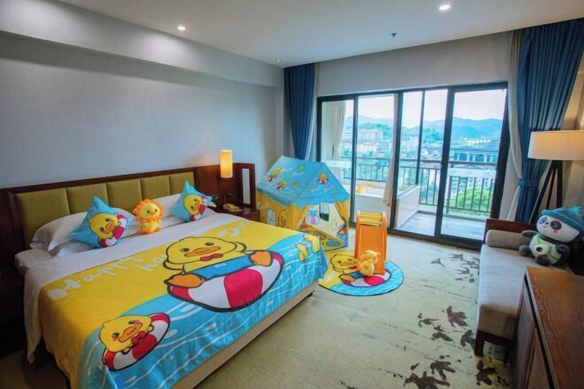 Habitación de hotel con una cama grande, un balcón y vistas de la ciudad.