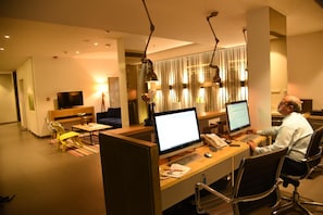 A modern office space with cubicles, computers, and a person working at a desk. - The Port Hotel (Visakhapatnam)