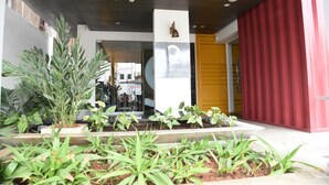 Ingresso di un hotel dal design moderno, con insegna e porta rossa.