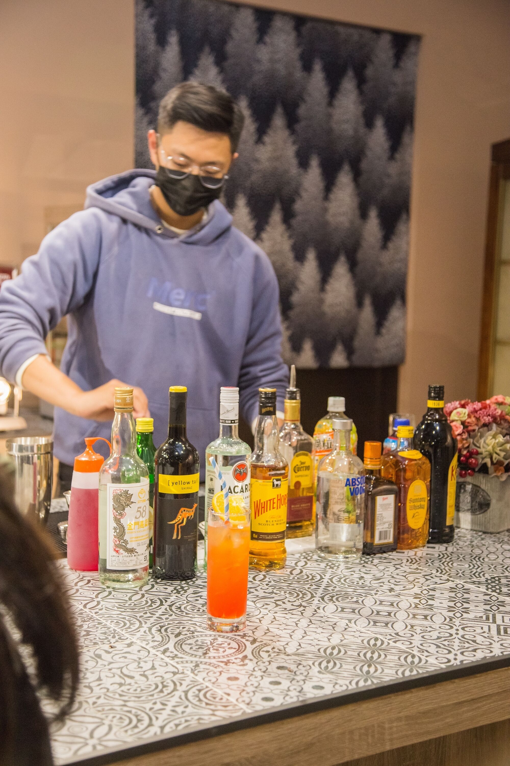 A bar area with a variety of liquor bottles on the counter.