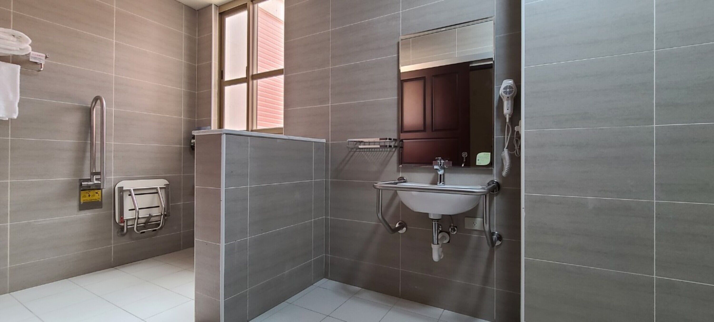 A modern bathroom with a walk-in shower, a sink with a vanity, and a towel rack.