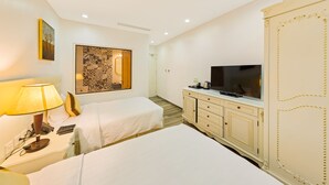 A hotel room with two beds, a TV, a cabinet, and a decorative wall piece.