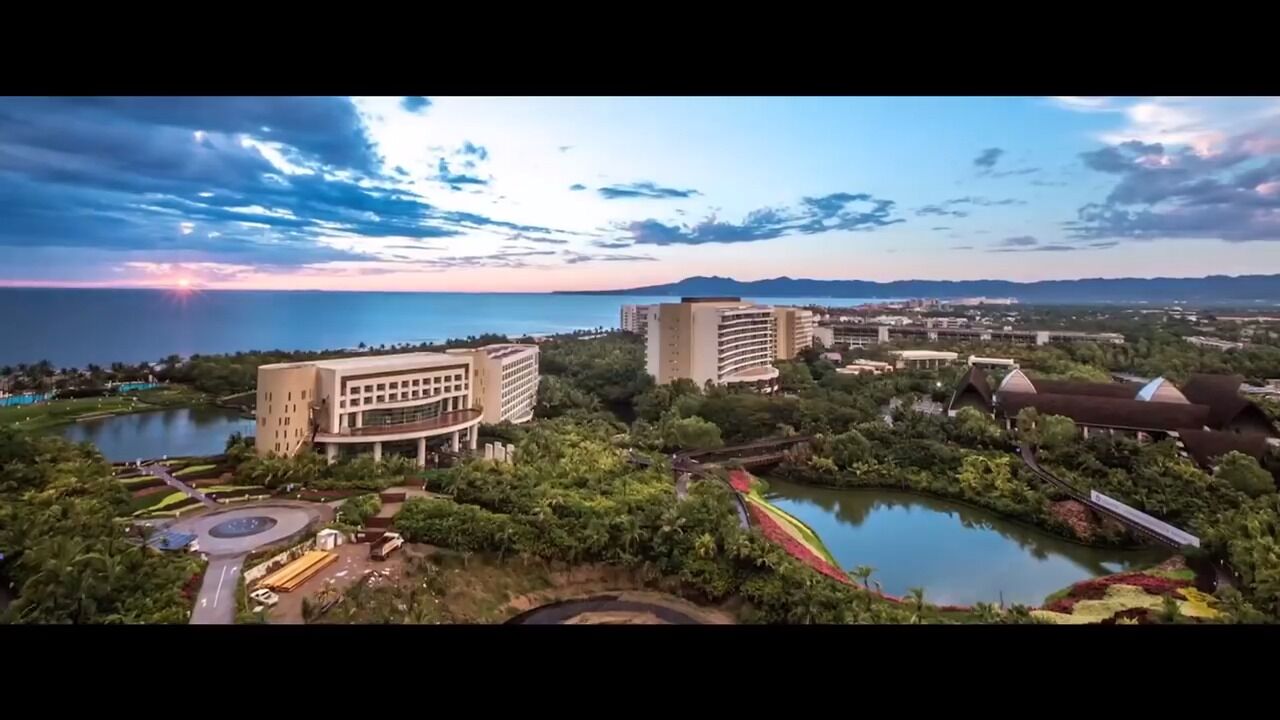 Un complejo hotelero con varias edificaciones, un lago y un puente.