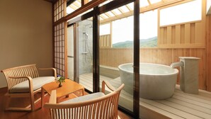 A wooden deck with a hot tub and a table with chairs. - Yugarawa Fuga (Yugawara)