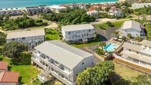 A coastal resort with multiple-story buildings, a swimming pool, and a view of the ocean. - Sandcastles by the Sea 402 - 30A, Community Pool, Steps to the Beach! (Blue Mountain Beach)