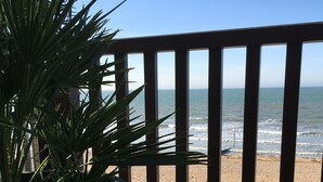 En balkon med udsigt over stranden og havet.