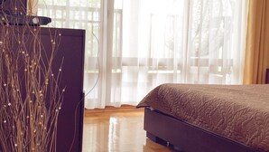 A bedroom with a bed, a dresser, and a vase with branches. - Generaator House (Pomorie)