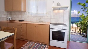 Una cucina compatta con mobili in legno, un piano cottura bianco e una finestra con vista panoramica.