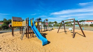 Ein Spielplatz mit einer blauen Rutsche und verschiedenen Spielgeräten.
