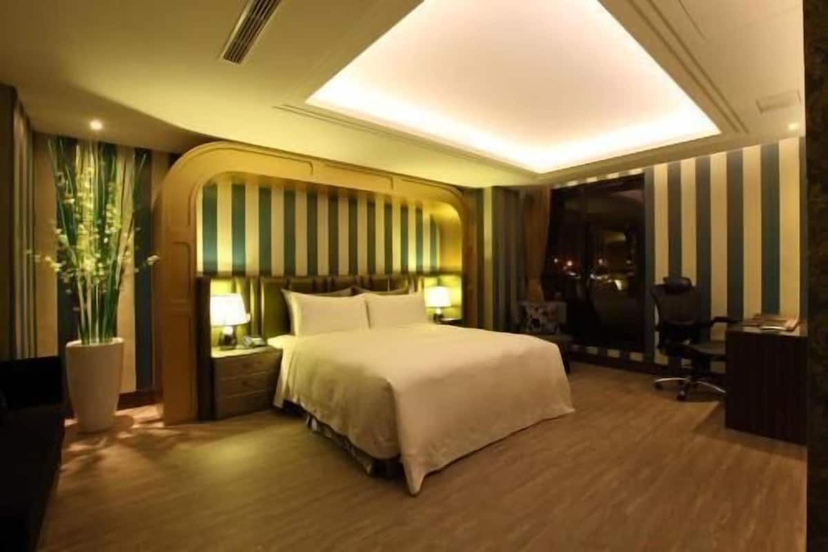 Une chambre d’hôtel comprenant un lit, des tables de chevet, un bureau et une chaise.