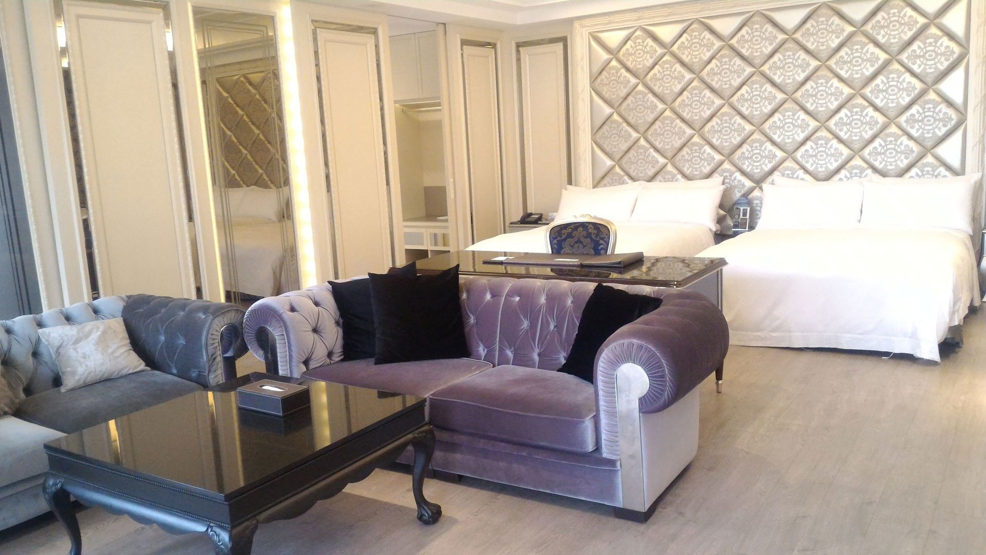 Una habitación de hotel con cama, sofá, mesa de centro y armario.