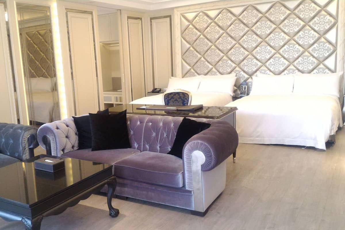Une chambre d’hôtel comprenant un lit, un canapé, une table basse et une armoire.