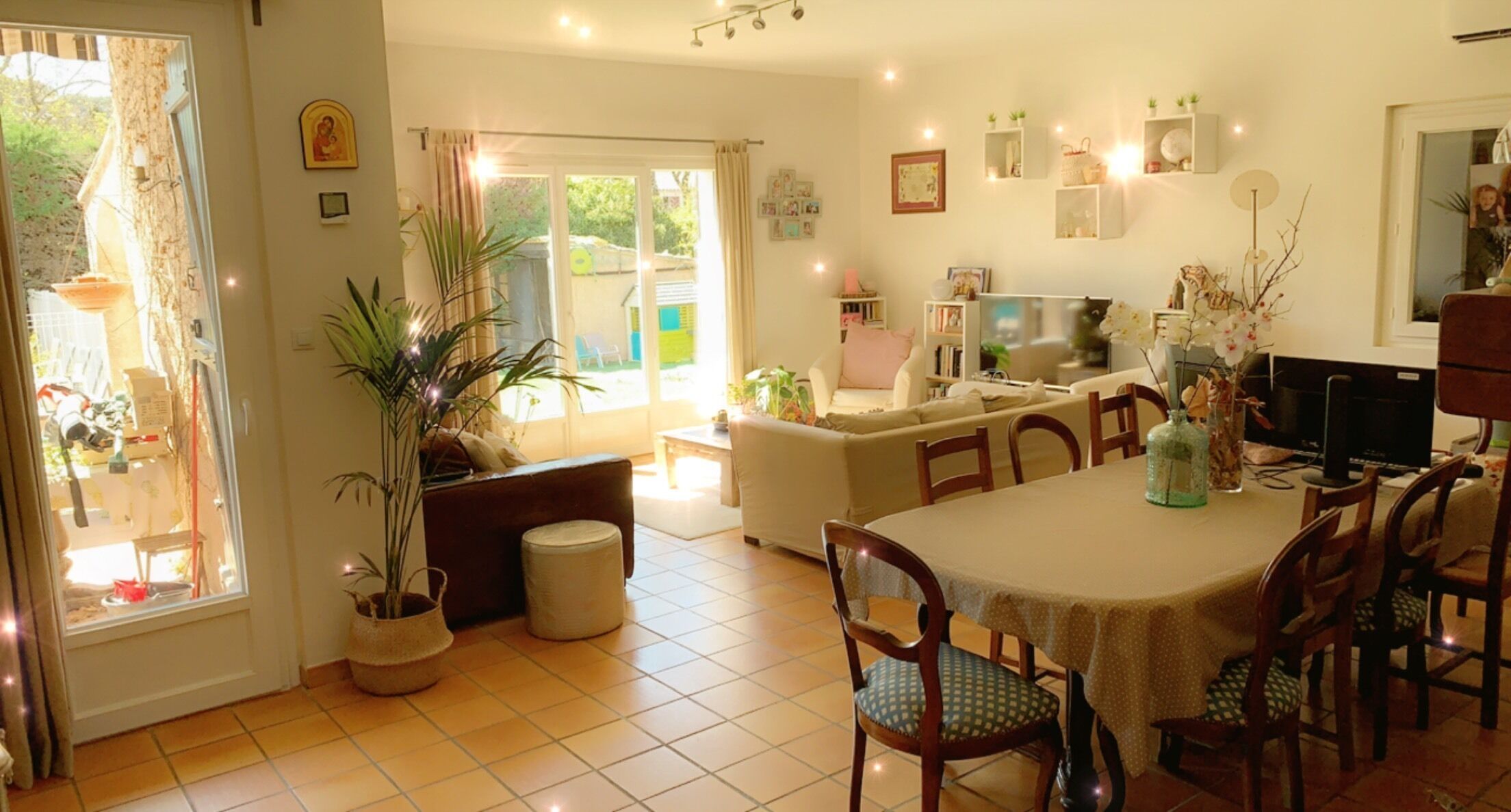 Un vaste espace de vie comprenant une table à manger, des chaises, un canapé et un téléviseur.