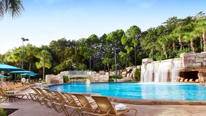 Un espace piscine doté de chaises longues et agrémenté d’une cascade.