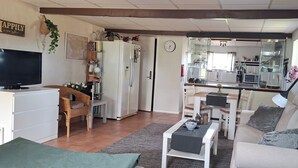 A living room with a TV, sofa, and a dining area with chairs and a table. - 1 Bed Flat - Sleeps 3 - Pets - Parking - Wifi (Tollarp)
