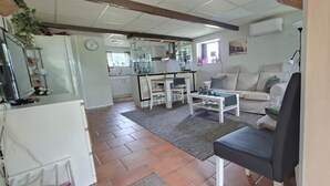 A living room with a sofa, a coffee table, and a dining area with a table and chairs. - 1 Bed Flat - Sleeps 3 - Pets - Parking - Wifi (Tollarp)