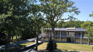 A modern building with a flat roof, large windows, and a covered walkway.