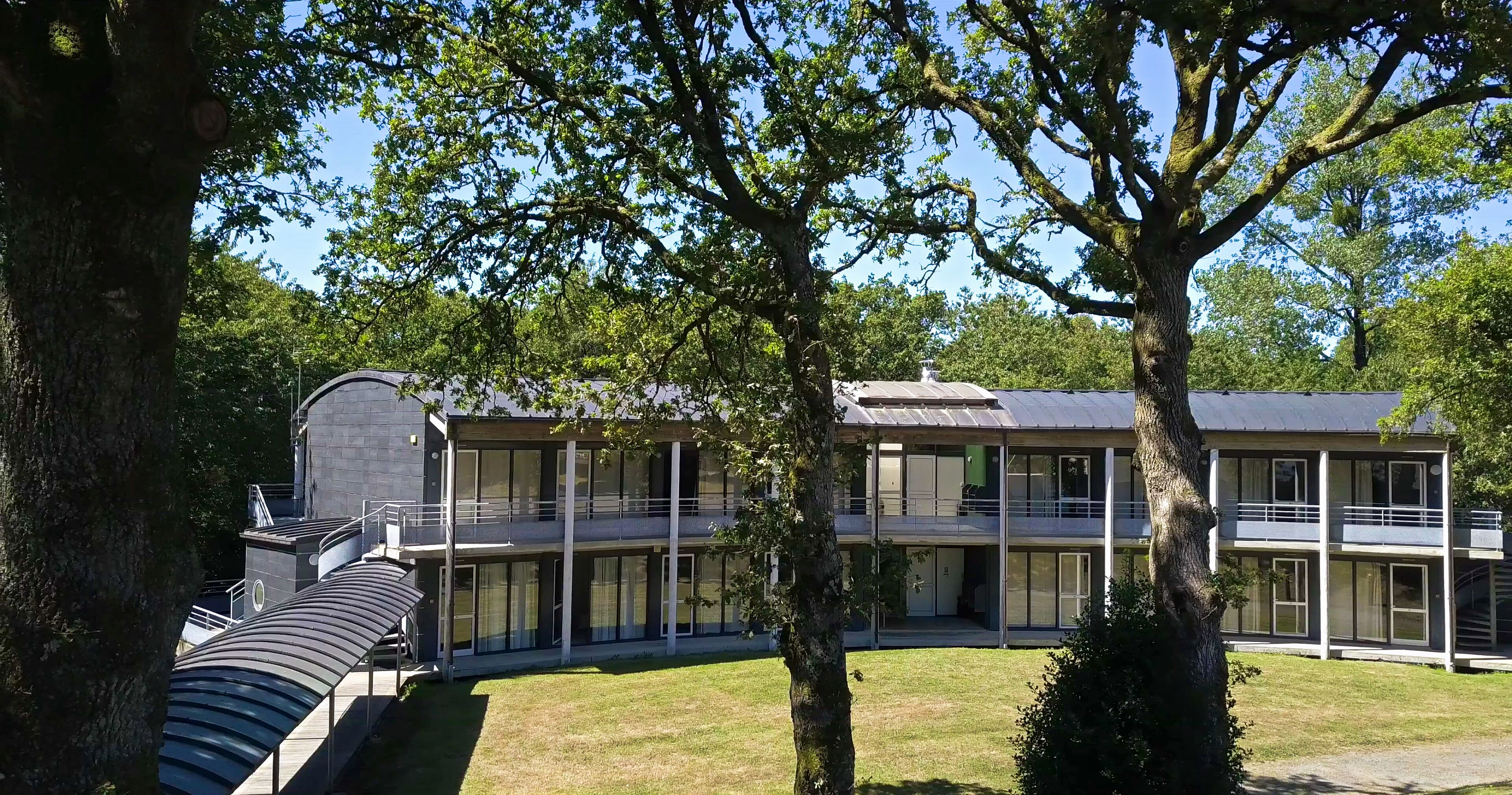 A modern building with a curved roof and multiple balconies.
