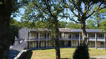 A modern building with a curved roof and multiple balconies.