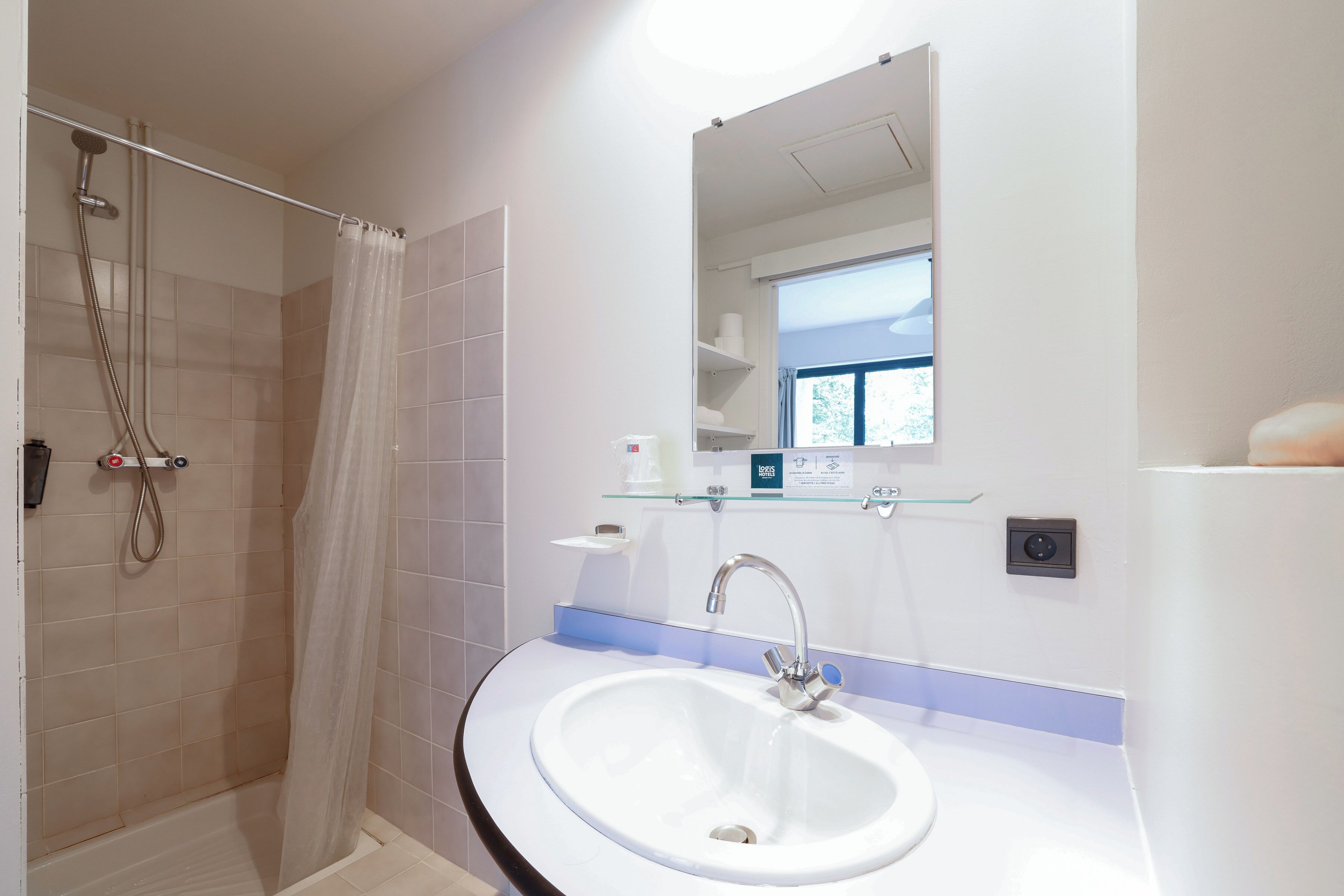 A bathroom with a shower, sink, and mirror.