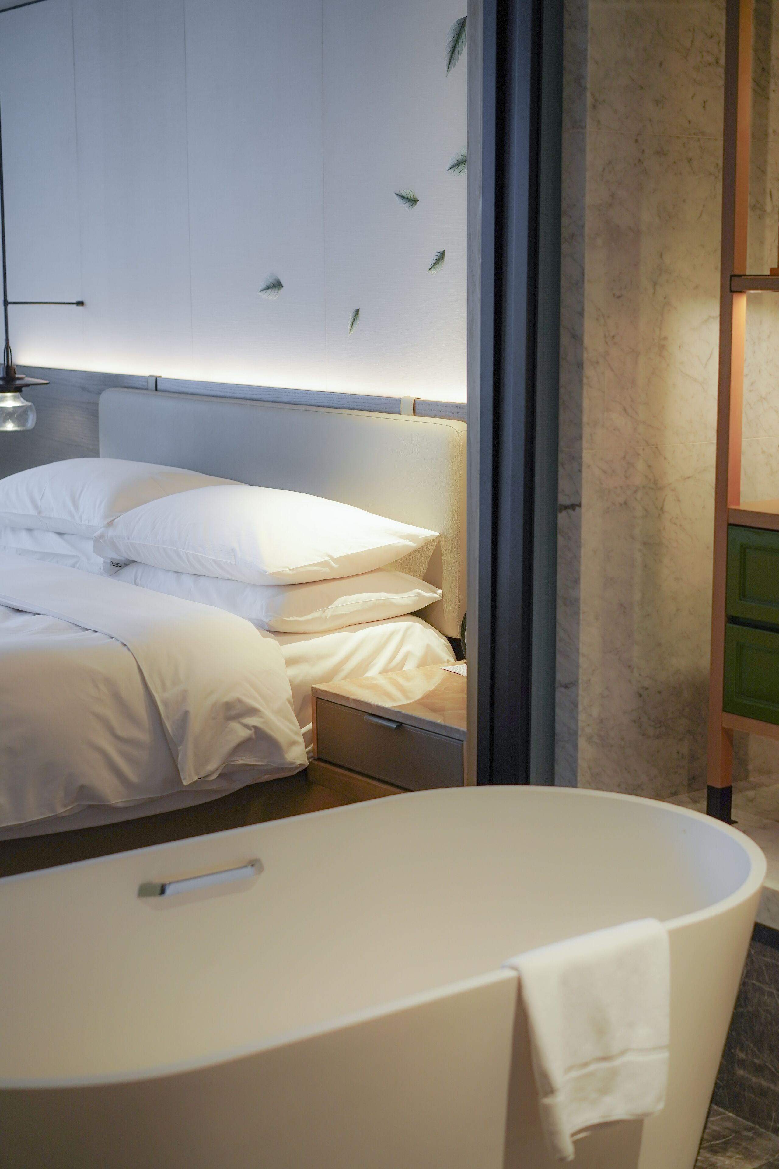 Ein modernes Schlafzimmer mit einem großen Bett, einem Nachttisch und einem fest eingebauten Nachtschränkchen.